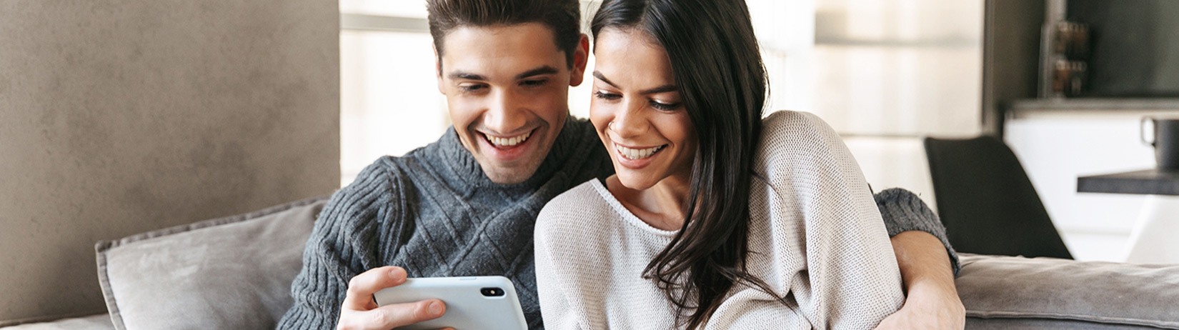 Happy couple using a smartphone - Hero Desktop