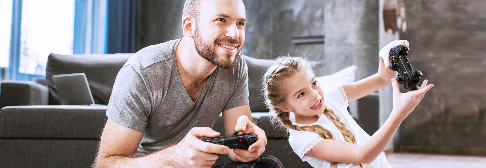 Father plays with his daughter on the console - Hero Desktop